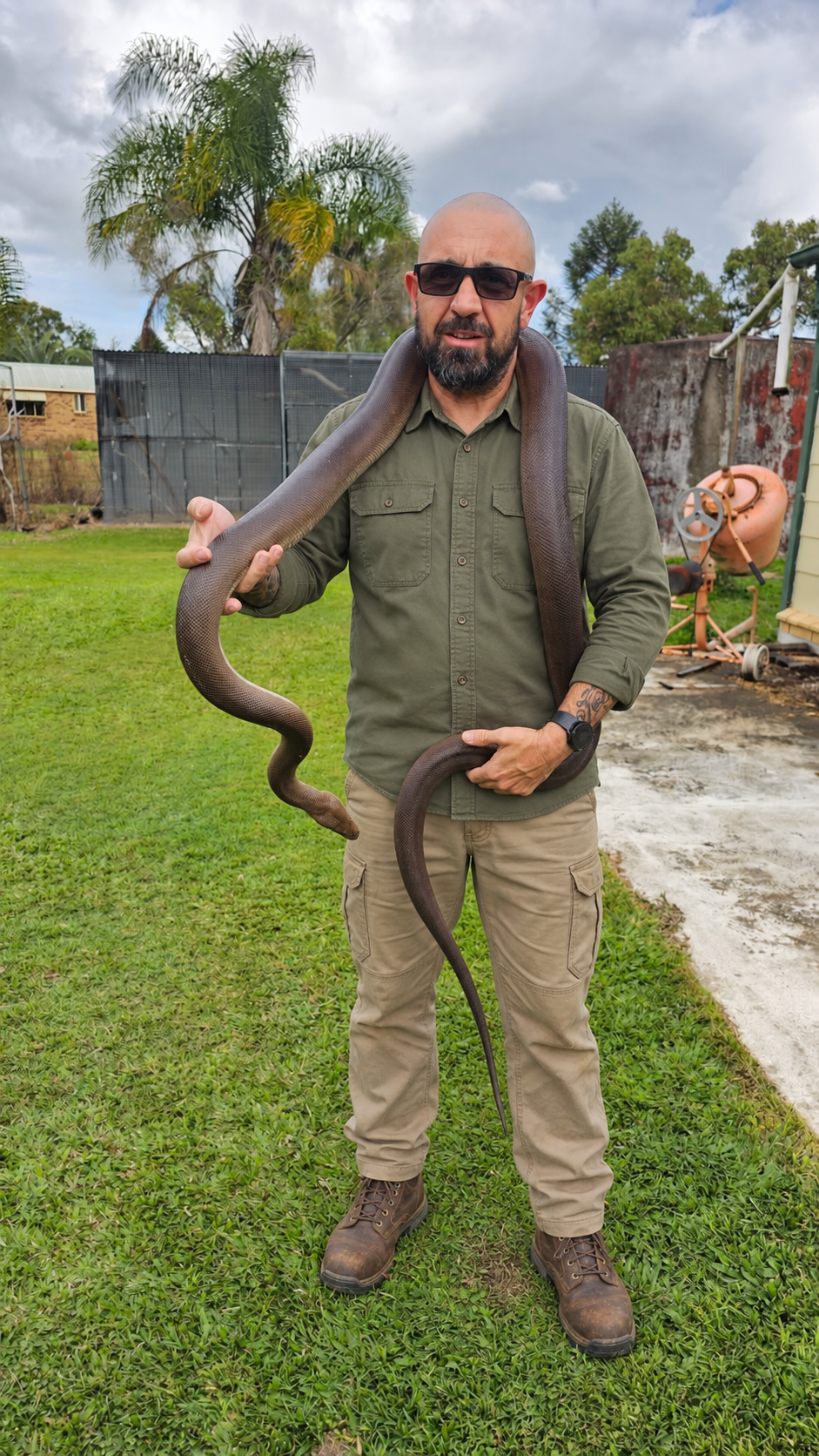 Russell holding a snake, with his field outfit digitally styled